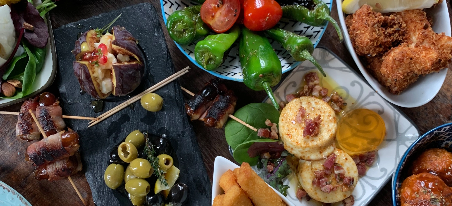 Frittiertes Essen im Taparazzi-Restaurant und gegrilltes Gemüse auf dem Tisch