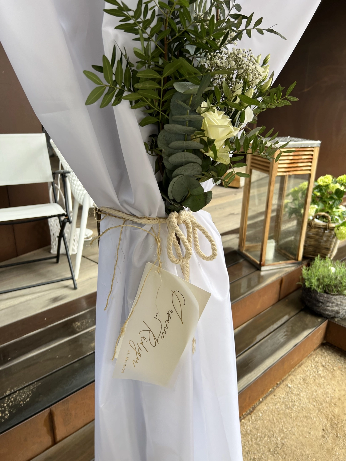 Taparazzi-Restaurant, mit Blumen geschmückter Mast, mit weißem Tuch bedeckt und mit einem Namensschild versehen